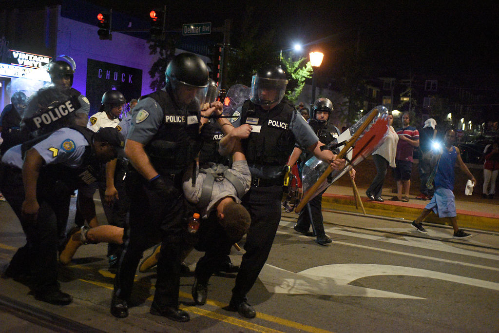 Police carry Jeffrey Blackman after arresting him during protests